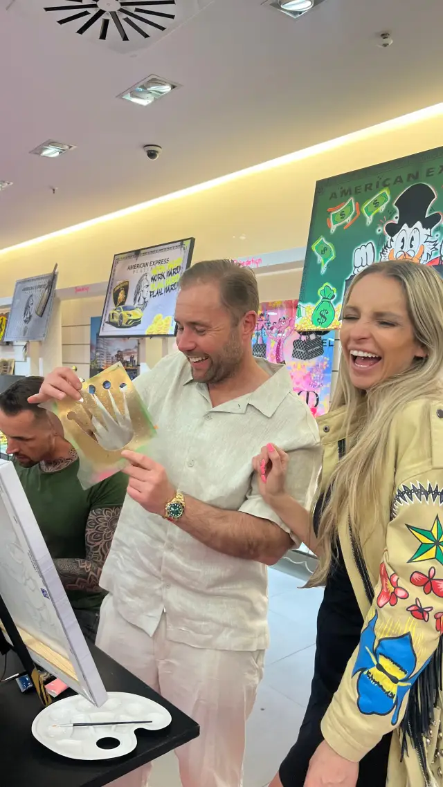 Malevent mit Babedesign: Ein Mann und eine Frau lachen und halten eine goldene Kronen-Schablone in der Hand
